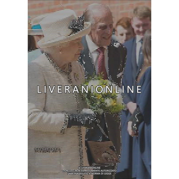 FELSTED, ENGLAND - MAY 06: Prince Phillip, Duke of Edinburgh and Queen Elizabeth II receives flowers during an official visit to Felsted School on May 6, 2014 in Felsted, England. Her Majesty unveiled two plaques to commemorate the School\'s 450th anniversary and completion of a new boarding house. AG ALDO LIVERANI SAS ONLY ITALY