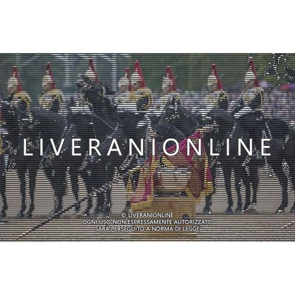 The new Standards of the household cavalry are unfurled and placed on drums for the Queen to inspect them during the ceremony on horse guards parade. The Queen presents the Household Cavalry with new standards once every decade. The Household Cavalry consists of the two senior regiments in the British Army; The Life Guards and The Blues and Royals. These two regiments form the SovereignÇƒÙs personal mounted body guard while also providing an operational Armoured Cavalry Regiment, equipped with CVR(T) vehicles. This parade sees the entire regiment, both mounted on horses and in armoured vehicles being inspected by Her Majesty on Horse Guards Parade. The Household Cavalry Regiment has recently returned from its last tour to Afghanistan having had six deployments since 2004. The Standards themselves have historically acted as a rallying point during battle and now carry all of the Battle Honours of both The Life Guards and The Blues and Royals. They carry huge significance as they represent four hundred years of history of service to the monarch and to the country. The Parade will begin with the Armoured Regiment and the Mounted Regiment forming up on Horse Guards Parade, when the outgoing standards are trooped and removed from the parade. ©photoshot/Agenzia Aldo Liverani sas - ITALY ONLY - REALI INGLESI: La Regina Elisabetta II d\'inghilterra e il principe Harry, durante la cerimonia per la parata delle guardie a cavallo
