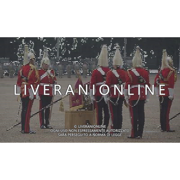 The new Standards of the household cavalry are unfurled and placed on drums for the Queen to inspect them during the ceremony on horse guards parade. The Queen presents the Household Cavalry with new standards once every decade. The Household Cavalry consists of the two senior regiments in the British Army; The Life Guards and The Blues and Royals. These two regiments form the Sovereign’s personal mounted body guard while also providing an operational Armoured Cavalry Regiment, equipped with CVR(T) vehicles. This parade sees the entire regiment, both mounted on horses and in armoured vehicles being inspected by Her Majesty on Horse Guards Parade. The Household Cavalry Regiment has recently returned from its last tour to Afghanistan having had six deployments since 2004. The Standards themselves have historically acted as a rallying point during battle and now carry all of the Battle Honours of both The Life Guards and The Blues and Royals. They carry huge significance as they represent four hundred years of history of service to the monarch and to the country. The Parade will begin with the Armoured Regiment and the Mounted Regiment forming up on Horse Guards Parade, when the outgoing standards are trooped and removed from the parade. ©PHOTOSHOT/Agenzia Aldo Liverani sas - ITALY ONLY - EDITORIAL USE ONLY ©photoshot/Agenzia Aldo Liverani sas - ITALY ONLY - REALI INGLESI: La Regina Elisabetta II d\'inghilterra e il principe Harry, durante la cerimonia per la parata delle guardie a cavallo