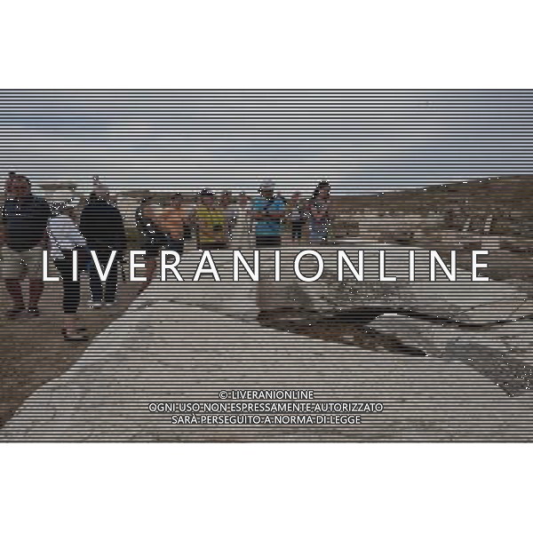 (140529) -- DELOS, May 29, 2014 () -- Tourists visit the remains of architecture on the island of Delos, Greece, on May 28, 2014. According to Greek mythology, Apollo was born on this tiny island in the Cyclades archipelago. Apollo\'s sanctuary attracted pilgrims from all over Greece and Delos was a prosperous trading port. The island bears traces of the succeeding civilizations in the Aegean world, from the 3rd millennium B.C. to the palaeochristian era. The archaeological site is exceptionally extensive and rich and conveys the image of a great cosmopolitan Mediterranean port. (/Liu Yongqiu) ©PHOTOSHOT/Agenzia Aldo Liverani sas - ITALY ONLY - EDITORIAL USE ONLY - Sito archeologico sulla Islanda di Delos, in Grecia nell\'arcipelago delle Cicladi patrimonio mondiale dell\'Unesco