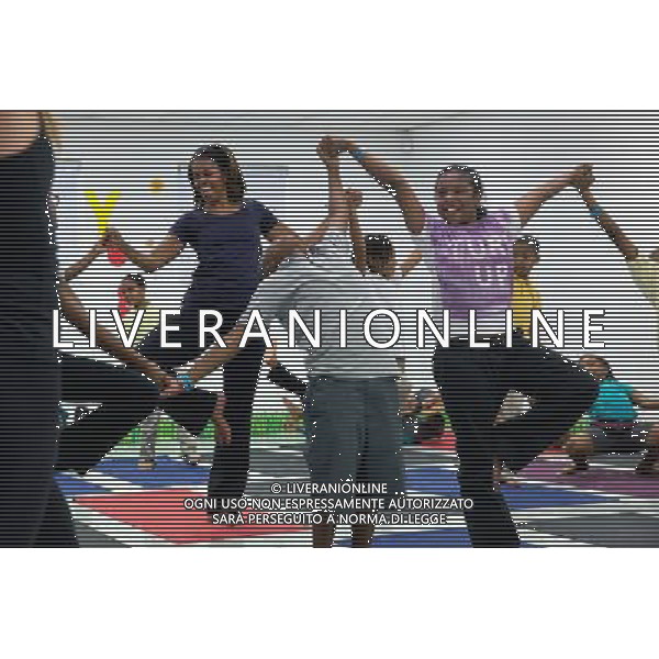 First Lady Michelle Obama joins children for a yoga class during a \'Let\'s Move!\' after school activities event at Gwen Cherry Park in Miami, Fla., Feb. 25, 2014. ©photoshot/Agenzia Aldo Liverani sas - ITALY ONLY - Il Presidente americano Barack Obama