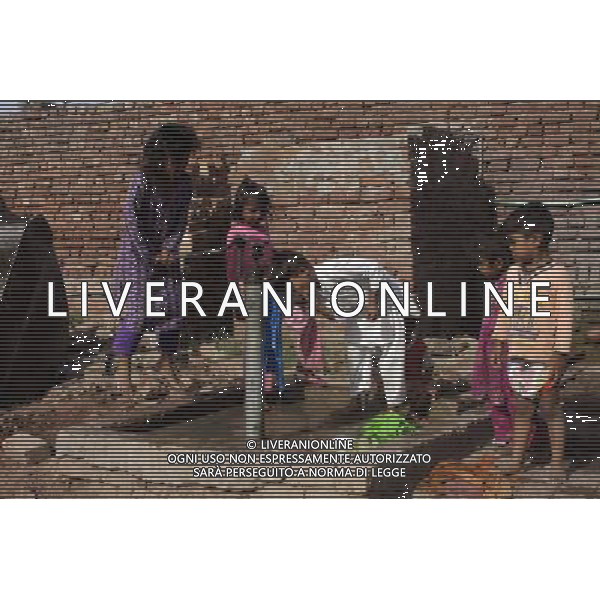 (140604) -- LAHORE, June 4, 2014 () -- A Pakistani girl pulls a hand-pump as a boy drinks water from it at a slum on the outskirts of eastern Pakistan\'s Lahore, June 4, 2014. (/Jamil Ahmed)(zhf) ©photoshot/Agenzia Aldo Liverani sas - ITALY ONLY - EDITORIAL USE ONLY - bambini pakistan in una baraccopoli alla periferia di del Pakistan orientale Lahore, 4 giugno 2014