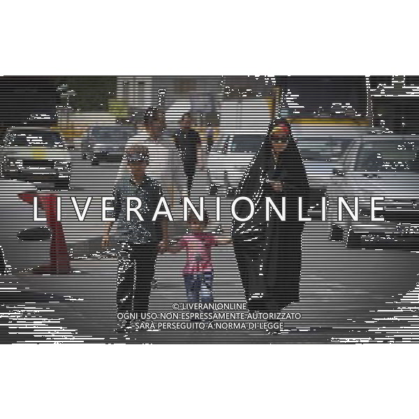 (140610) -- MASHHAD, June 10, 2014 () -- A woman and her children cross a street near the Imam Reza shrine in Mashhad, Iran, June 9, 2014. Mashhad is the second largest city in Iran and one of the holiest cities in the Shia Muslim world. (/Ahmad Halabisaz) ©PHOTOSHOT/Agenzia Aldo Liverani sas - ITALY ONLY - EDITORIAL USE ONLY - Vita quotidiana della popolazione vicino al santuario dell\'Imam Reza a Mashhad, in Iran, il 9 giugno 2014 la seconda citta\' piu\' grande in Iran e una delle citta\' piu\' sacra del mondo musulmano sciita.