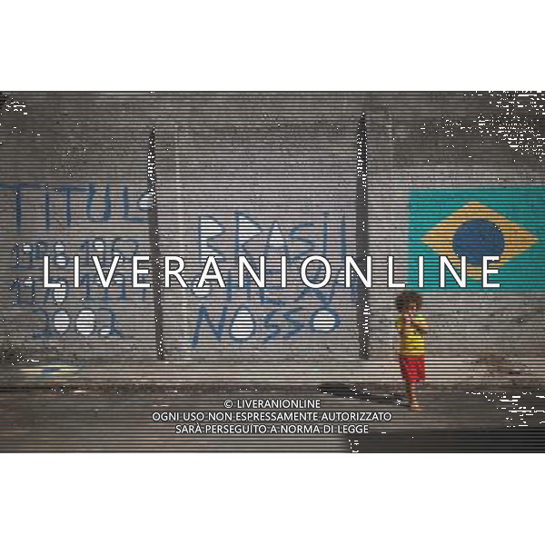 (140611) -- SALVADOR, June 11, 2014 () -- A child plays in front of graffiti near the Fonte Nova Stadium in Salvador, Brazil, on June 11, 2014. The 2014 FIFA World Cup will be held in Brazil from June 12 to July 13.(/Jhon Paz) (rh) ©PHOTOSHOT/Agenzia Aldo Liverani sas - ITALY ONLY - EDITORIAL USE ONLY - Preparativi e attesa dell\'inizio della coppa del mondo FIFA Brasile 2014