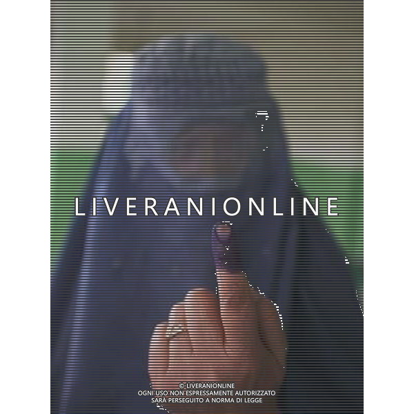 (140614) -- KABUL, June 14, 2014 () -- A woman shows her inked finger after casting her vote at a polling station in Kabul, Afghanistan, on June 14, 2014. Polls opened Saturday morning in Afghan presidential election runoff, with Election Commission Chairman Ahmad Yusuf Nuristani being the first to cast his vote to elect the country\'s next president. (/Ahmad Massoud) ©PHOTOSHOT/Agenzia Aldo Liverani Sas - ITALY ONLY - EDITORIAL USE ONLY - Votazione per il ballottaggio delle elezioni presidenziali in un centro elettorale a Kabul, in Afghanistan, il 14 giugno, 2014