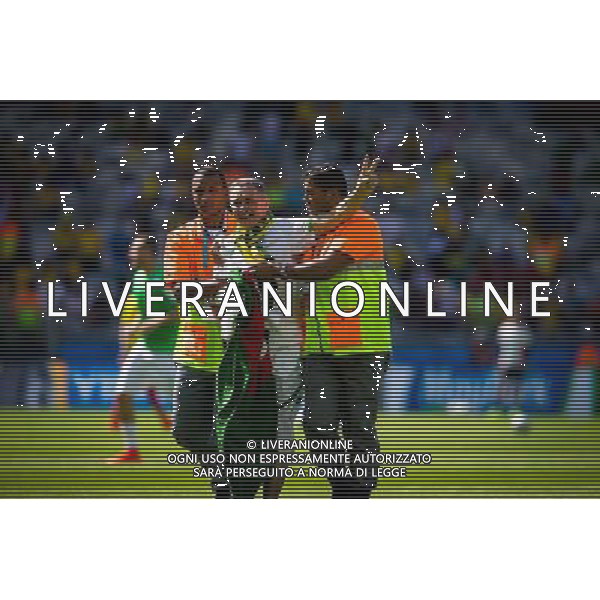 (140617) -- BELO HORIZONTE, June 17, 2014 () -- A fan (C) is escorted by the security guards as he jumped into the pitch prior to a Group H match between Belgium and Algeria of 2014 FIFA World Cup at the Estadio Mineirao Stadium in Belo Horizonte, Brazil, June 17, 2014.(/Liu Bin)(xzj) AG ALDO LIVERANI SAS ONLY ITALY