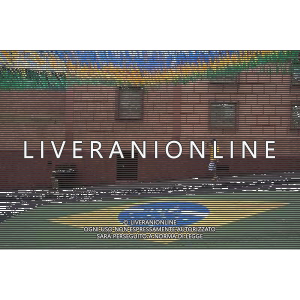 (140617) -- MANAUS, June 17, 2014 () -- A man walks by a Brazilian flag on the street in downtown Manaus city, Brazil, on June 17, 2014. (/Guillermo Arias)(rh) ©PHOTOSHOT/Agenzia Aldo Liverani sas - ITALY ONLY - EDITORIAL USE ONLY - Souvenir della coppa del mondo brasiliana sulla strada nel centro della citta\' di Manaus, in Brasile, il 17 giugno 2014
