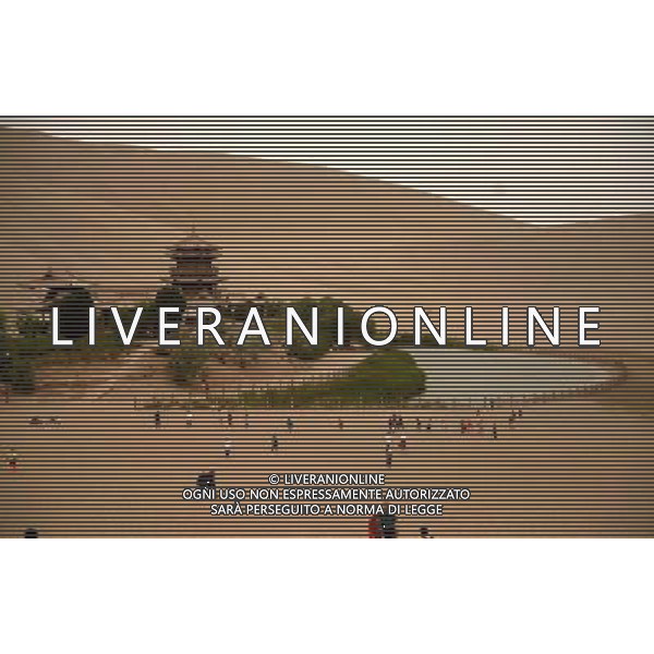 (140618) -- DUNHUANG, June 18, 2014 () -- Tourists visit the Mingshashan, literally \'singing-sand mountain\', and the Crescent Lake, an oasis scenic spot in the Gobi Desert in Dunhuang, northwest China\'s Gansu Province, June 17, 2014. (/Nie Jianjiang) (wf) ©PHOTOSHOT/Agenzia Aldo Liverani sas - ITALY ONLY - EDITORIAL USE ONLY - I turisti visitano l\'oasi del deserto, circa 90 km a nord ovest di Dunhuang citta\' lungo l\'antica Via della Seta in della Cina nord-occidentale di Gansu Province, 17 giugno 2014