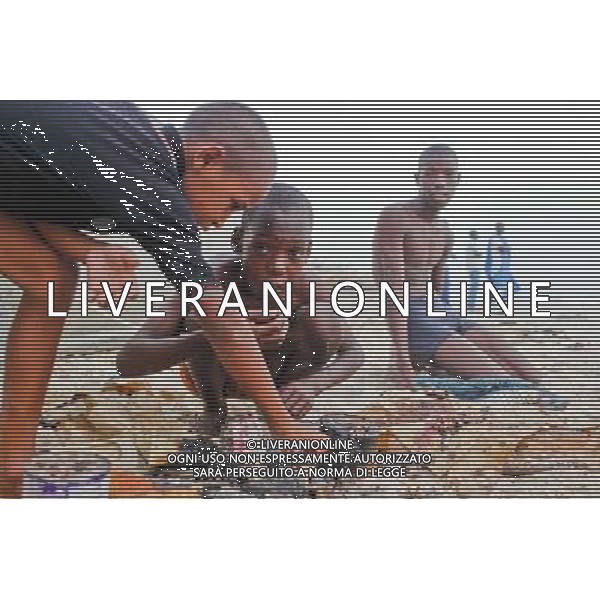 (140623) -- NOUAKCHOTT, June 23, 2014 () -- Boys grill fish at a fish market in Nouakchott, capital of Mauritania, June 22, 2014. (/Li Jing) (zjl) ©PHOTOSHOT/Agenzia Aldo Liverani sas - ITALY ONLY - EDITORIAL USE ONLY - Vita quotidiana della popolazione a Nouakchott, capitale della Mauritania, 22 giugno 2014