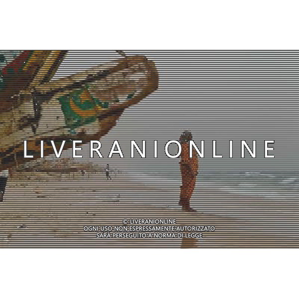 (140623) -- NOUAKCHOTT, June 23, 2014 () -- A woman takes a walk on the beach near a fish market in Nouakchott, capital of Mauritania, June 22, 2014. (/Li Jing)(zjl) ©PHOTOSHOT/Agenzia Aldo Liverani sas - ITALY ONLY - EDITORIAL USE ONLY - Vita quotidiana della popolazione a Nouakchott, capitale della Mauritania, 22 giugno 2014