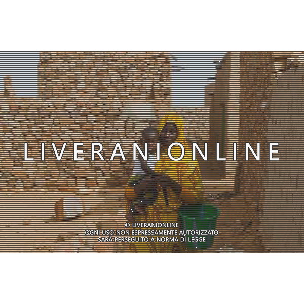 (140626) -- CHINGEUTTI , June 26, 2014 () -- A woman walks with her baby at Ouadane ancient town, in Adrar Region, Mauritania, June 24, 2014. (/Li Jing)(lyi) ©PHOTOHOT/Agenzia Aldo Liverani sas - ITALY ONLY - EDITORIAL USE ONLY - Vedute della citta\' di Chinguetti, in Adrar Regione, Mauritania.