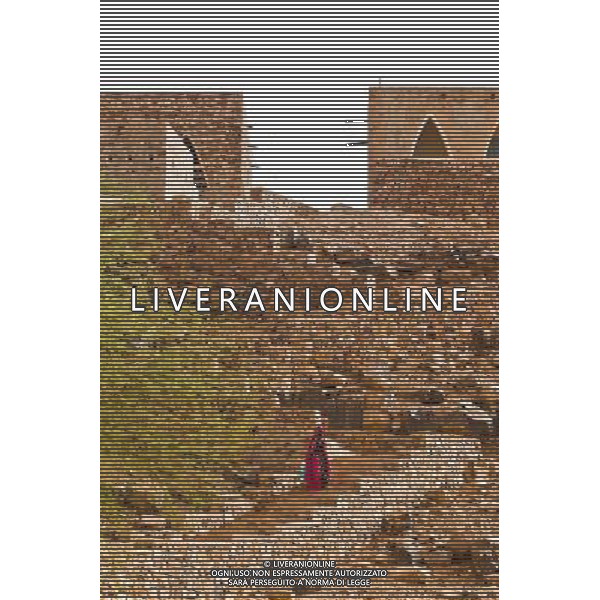 (140626) -- CHINGEUTTI, June 26, 2014 () -- A woman walks out of Ouadane town, in Adrar Region, Mauritania, June 24, 2014. (/Li Jing)(lyi) ©PHOTOHOT/Agenzia Aldo Liverani sas - ITALY ONLY - EDITORIAL USE ONLY - Vedute della citta\' di Chinguetti, in Adrar Regione, Mauritania.