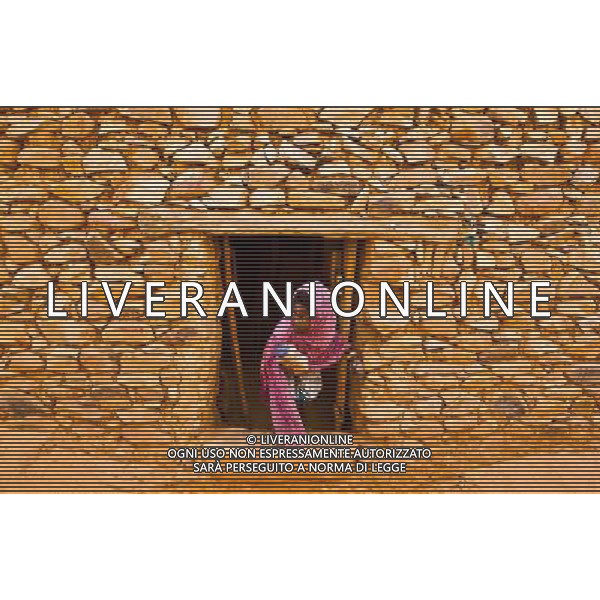 (140626) -- CHINGEUTTI, June 26, 2014 () -- A girl looks out of the door in the ancient city of Chinguetti, in Adrar Region, Mauritania, June 23, 2014. (/Li Jing) (lyi) ©PHOTOHOT/Agenzia Aldo Liverani sas - ITALY ONLY - EDITORIAL USE ONLY - Vedute della citta\' di Chinguetti, in Adrar Regione, Mauritania.