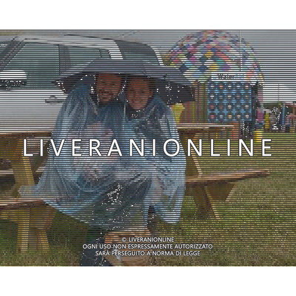 Pilton, UK, 27/06/2014 : Atmosphere at Glastonbury Festival. People shelter from a sudden torrential shower in the late afternoon. AG ALDO LIVERANI SAS ONLY ITALY