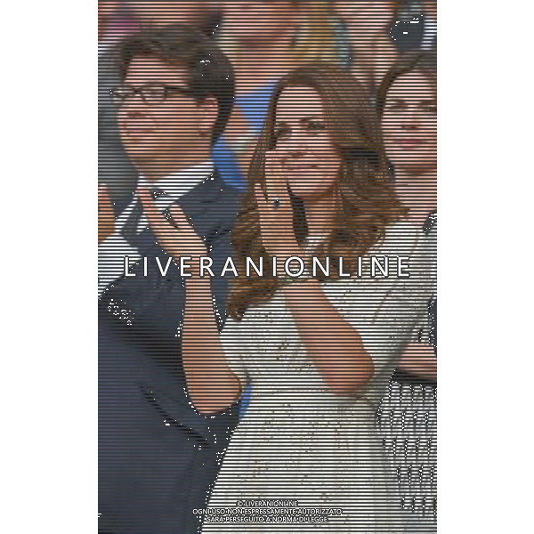 kate, Duchess of Cambridge, flanked by comedian Michael McIntyre clap the end of the mens quarter final match between Roger Federer and Stan Wawrinka.