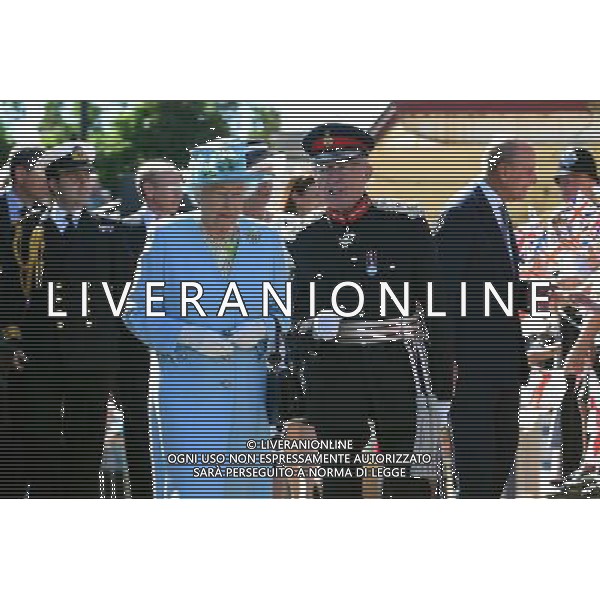 Queen Elizabeth II walks with Lord Lieutenant of Derbyshire, William Tucker (centre) as the Duke of Edinburgh (right) meets local school children following their arrival at Matlock Station. ©PHOTOSHOT/Agenzia Aldo Liverani sas - - ITALY ONLY - EDITORIAL USE ONLY - REALI INGLESI: La regina Elisabetta II d\'Inghilterra e il marito Principe Filippo durante la loro visita nel Derbeyshire, Gran Bretagna - 10 luglio 2014