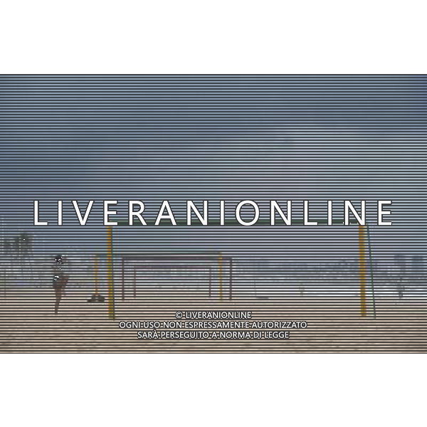 (140710) -- SALVADOR, July 10, 2014 () -- A man warms up beside goalposts in the early morning on a beach in Salvador, Brazil, on July 7, 2014. (/Yang Lei) ©PHOTOSHOT/Agenzia Aldo Liverani sas - - ITALY ONLY - EDITORIAL USE ONLY - La popolazione locale si gode la spiaggia e il mare a Salvador, in Brasile, 3 luglio 2014