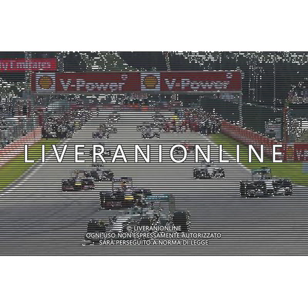 Nico Rosberg (GER) Mercedes AMG F1 W05 leads away on the formation lap as Ferrari mechanics on the grid work on the Ferrari F14-T of Fernando Alonso (ESP) Ferrari. 24.08.2014. Formula 1 World Championship, Rd 12, Belgian Grand Prix, Spa Francorchamps, Belgium, Race Day. AG ALDO LIVERANI SAS ONLY ITALY