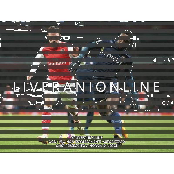 Southampton\'s Emmanuel Mayuka under pressure from Arsenal\'s Lukas Podolski Photographer Kieran Galvin/CameraSport Football - Barclays Premiership - Arsenal v Southampton - Wednesday 3rd December 2014 - The Emirates Stadium - London © CameraSport - 43 Linden Ave. Countesthorpe. Leicester. England. LE8 5PG - Tel: +44 (0) 116 277 4147 - admin@camerasport.com - www.camerasport.com AG ALDO LIVERANI SAS ONLY ITALY