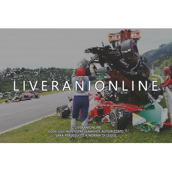 Marshals remove the start crash involving Fernando Alonso (ESP) McLaren MP4-30 and Kimi Raikkonen (FIN) Ferrari SF15-T. 21.06.2015. Formula 1 World Championship, Rd 8, Austrian Grand Prix, Spielberg, Austria, Race Day. /AGENZIA ALDO LIVERANI Sas - ITALY ONLY - EDITORIAL USE ONLY - GARA