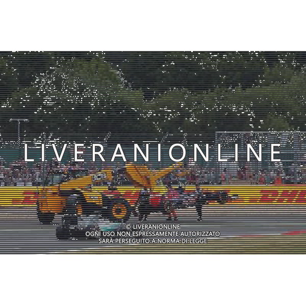 Lewis Hamilton (GBR) Mercedes AMG F1 W06 passes the Scuderia Toro Rosso STR10 of Carlos Sainz Jr (ESP) Scuderia Toro Rosso as it is craned off the circuit. 05.07.2015. Formula 1 World Championship, Rd 9, British Grand Prix, Silverstone, England, Race Day. AG ALDO LIVERANI SAS ONLY ITALY
