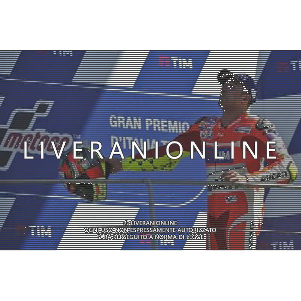 Andrea Iannone lancia il casco dopo il podio FOTO G-PIAZZOLLA-AG ALDO LIVERANI SAS