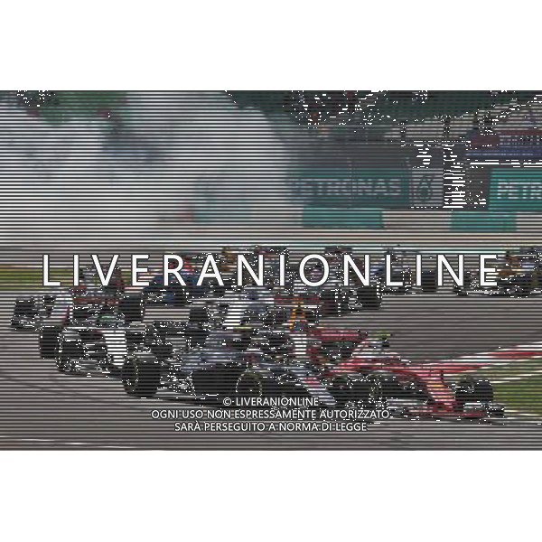 Jenson Button (GBR) McLaren MP4-31 and Kimi Raikkonen (FIN) Ferrari SF16-H at the start of the race. 02.10.2016. Formula 1 World Championship, Rd 16, Malaysian Grand Prix, Sepang, Malaysia, Sunday. AG ALDO LIVERANI SAS ONLY ITALY