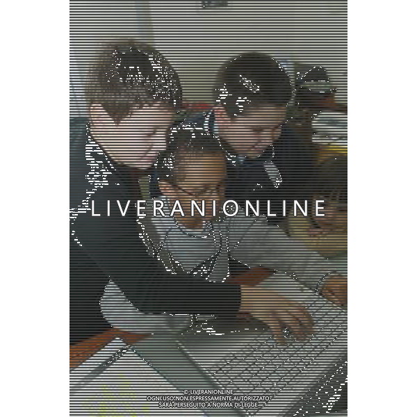 Brescia 10/03/2003 nella foto gruppo di ragazzi bambini e bambino di colore che studiano e giocano con il computer foto filippo venezia-A.Liverani
