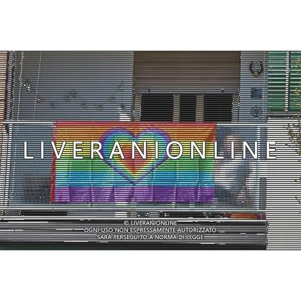 IMOLA 02 04 2020 EMERGENZA CORONAVIRUS NELLA FOTO PERSONA AL TELEFONO SUL TERRAZZO CON STRISCIONE ARCOBALENO E CUORE DURANTE LA QUARANTENA ©SANNA/ AGENZIA ALDO LIVERANI SAS