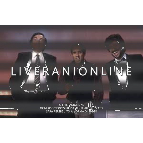 RETROSPETTIVA ADRIANO CELENTANO ATTORE CANTANTE NELLA FOTO ADRIANO CELENTANO CON PIPPO BAUDO E GIGI PROIETTI NELLA TRASMISSIONE TELEVISIVA “FANTASTICO“ AG ALDO LIVERANI SAS
