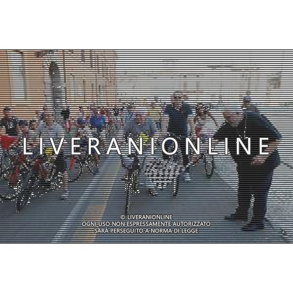 IMOLA 12 08 2022 PEDALATA DI SAN CASSIANO SOSTA AGLI SCAVI E AL CIPPO DI SAN CASSIANO NELLA FOTO IL VESCOVO GIOVANNI MOSCIATTI ABBASSA LA BANDIERA SCACCHI PER DARE IL INVIA ALLA PEDALATA DI SAN CASSIANO