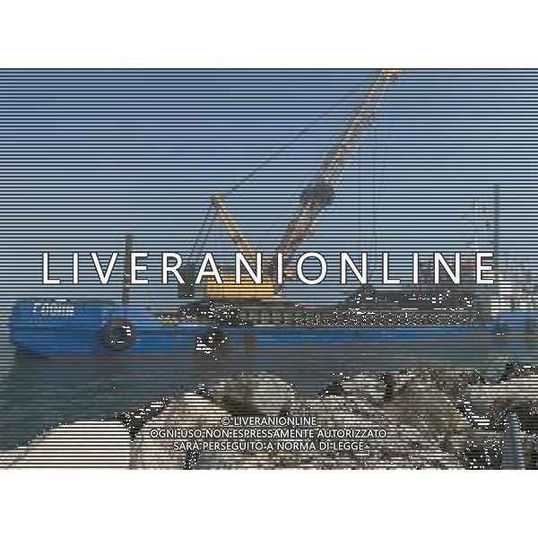 Chiatta con gru per i lavori di rimozione, sistemazione e consolidamento della scogliera sulla banchina al molo del Porto di Rimini Febbraio 2023 ©Agenzia Aldo Liverani Sas
