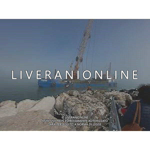 Chiatta con gru per i lavori di rimozione, sistemazione e consolidamento della scogliera sulla banchina al molo del Porto di Rimini Febbraio 2023 ©Agenzia Aldo Liverani Sas