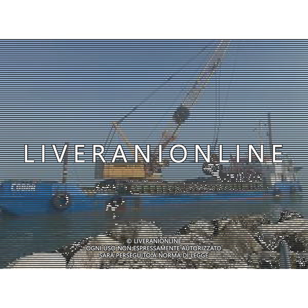 Chiatta con gru per i lavori di rimozione, sistemazione e consolidamento della scogliera sulla banchina al molo del Porto di Rimini Febbraio 2023 ©Agenzia Aldo Liverani Sas