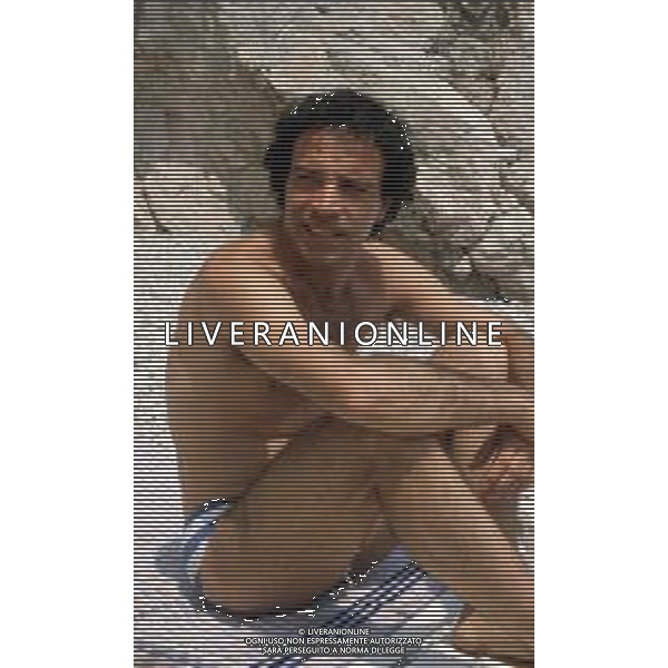 DIAP-RETROSPETTIVA ENRICO MONTESANO ATTORE NELLA FOTO ENRICO MONTESANO NELL\'ANNO 1983 IN SPIAGGIA AL MARE A TAORMINA AG ALDO LIVERANI SAS