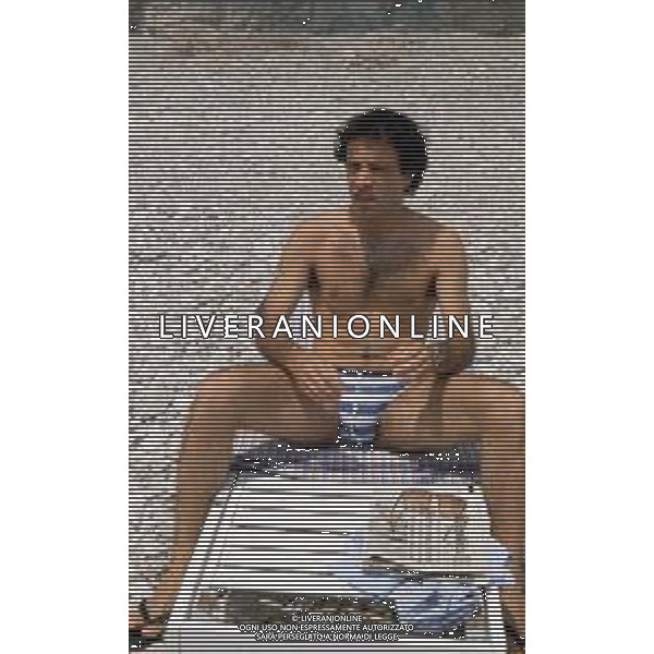 DIAP-RETROSPETTIVA ENRICO MONTESANO ATTORE NELLA FOTO ENRICO MONTESANO NELL\'ANNO 1983 IN SPIAGGIA AL MARE A TAORMINA AG ALDO LIVERANI SAS