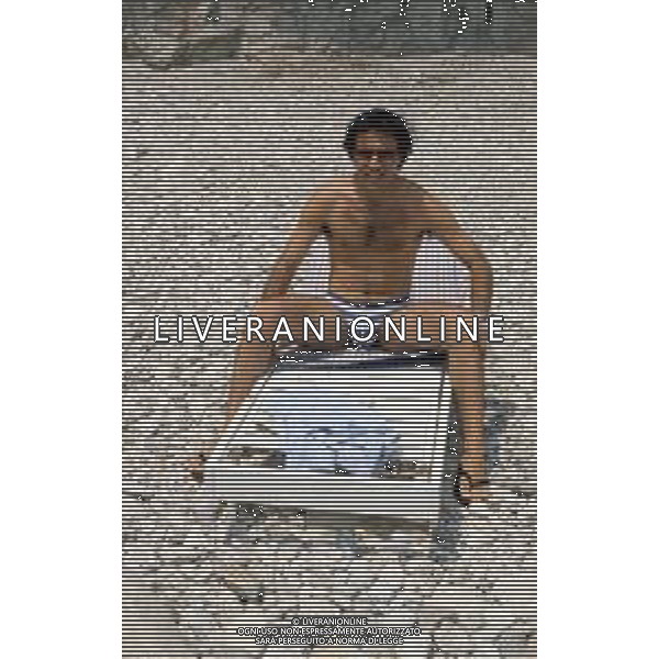 DIAP-RETROSPETTIVA ENRICO MONTESANO ATTORE NELLA FOTO ENRICO MONTESANO NELL\'ANNO 1983 IN SPIAGGIA AL MARE A TAORMINA AG ALDO LIVERANI SAS