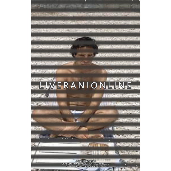 DIAP-RETROSPETTIVA ENRICO MONTESANO ATTORE NELLA FOTO ENRICO MONTESANO NELL\'ANNO 1983 IN SPIAGGIA AL MARE A TAORMINA AG ALDO LIVERANI SAS