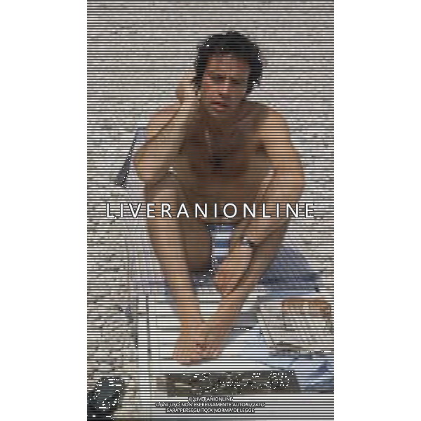 DIAP-RETROSPETTIVA ENRICO MONTESANO ATTORE NELLA FOTO ENRICO MONTESANO NELL\'ANNO 1983 IN SPIAGGIA AL MARE A TAORMINA AG ALDO LIVERANI SAS
