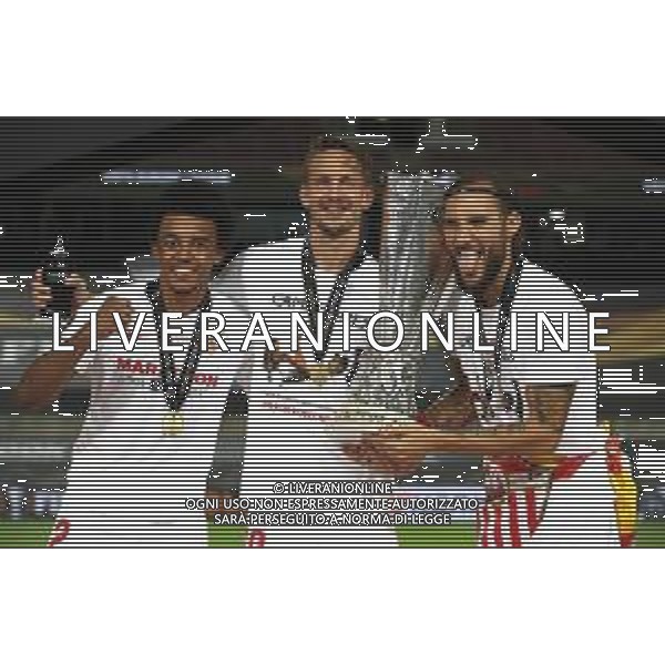 COLOGNE, GERMANY - AUGUST 21: Jules Kounde, Luuk de Jong, and Nemanja Gudelj of Sevilla celebrate with the UEFA Europa League Trophy following their team\'s victory in the UEFA Europa League Final between Seville and FC Internazionale at RheinEnergieStadion on August 21, 2020 in Cologne, Germany. (Photo by Alexander Hassenstein - UEFA/UEFA via Getty Images) AG ALDO LIVERANI SAS